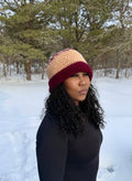 Brown and burgundy oversize beanie, soft stretchy acrylic, worn by woman in snowy outdoor setting.